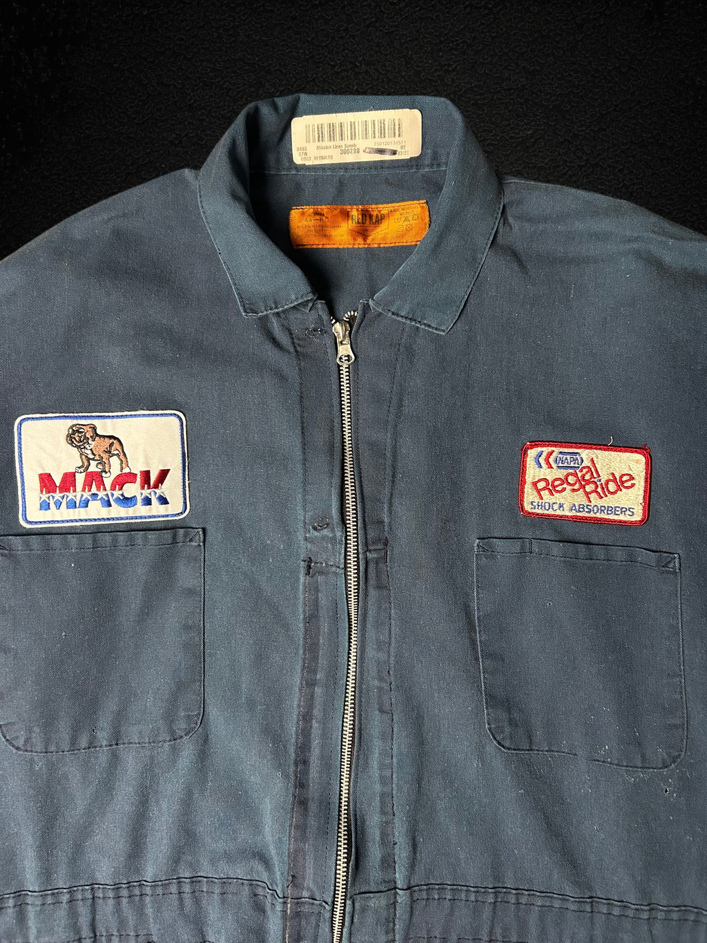Camino’s Auto Parts upcycled navy blue cropped trucker jacket with Mack Trucks and Napa vintage patches.