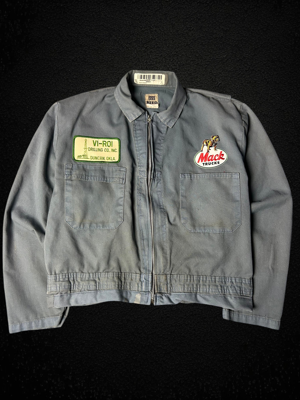 Camino’s Auto Parts upcycled blue Mack Truck trucker jacket with vintage patches and distressed detailing.