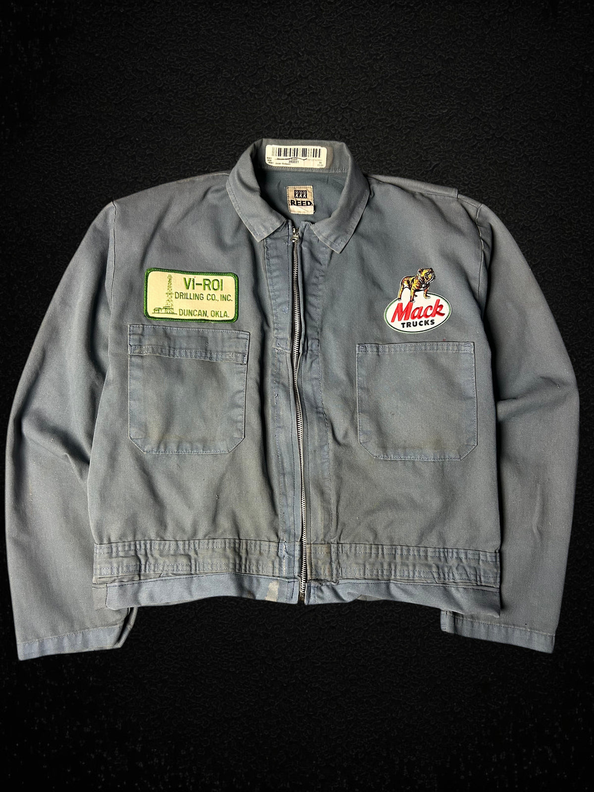 Camino’s Auto Parts upcycled blue Mack Truck trucker jacket with vintage patches and distressed detailing.