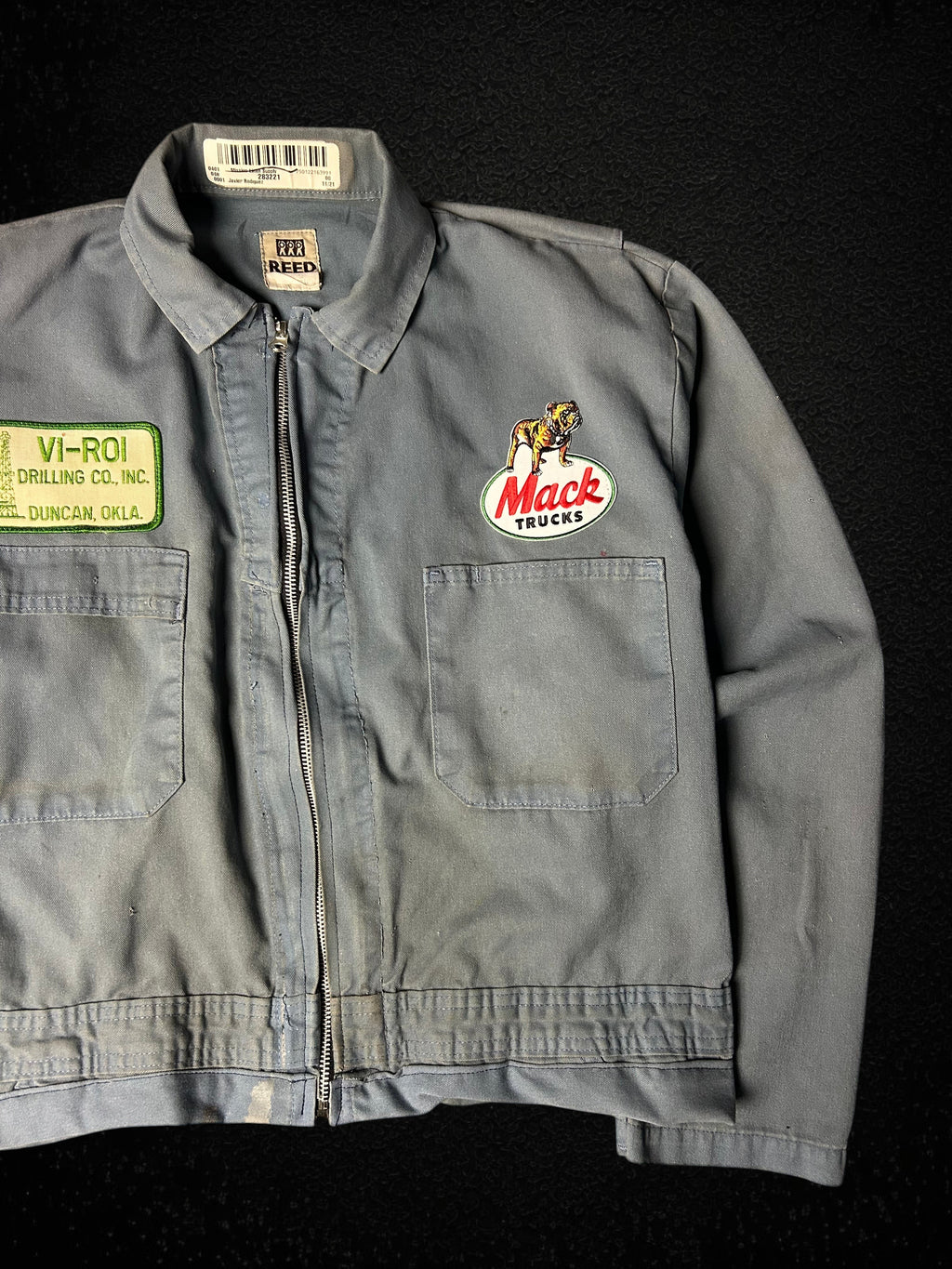 Camino’s Auto Parts upcycled grey Mack Truck trucker jacket with vintage patches and distressed detailing.