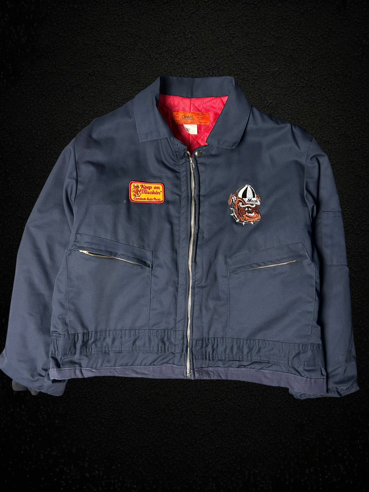 Camino’s Auto Parts upcycled navy insulated trucker jacket with Mack Trucks Bulldog and custom patches.