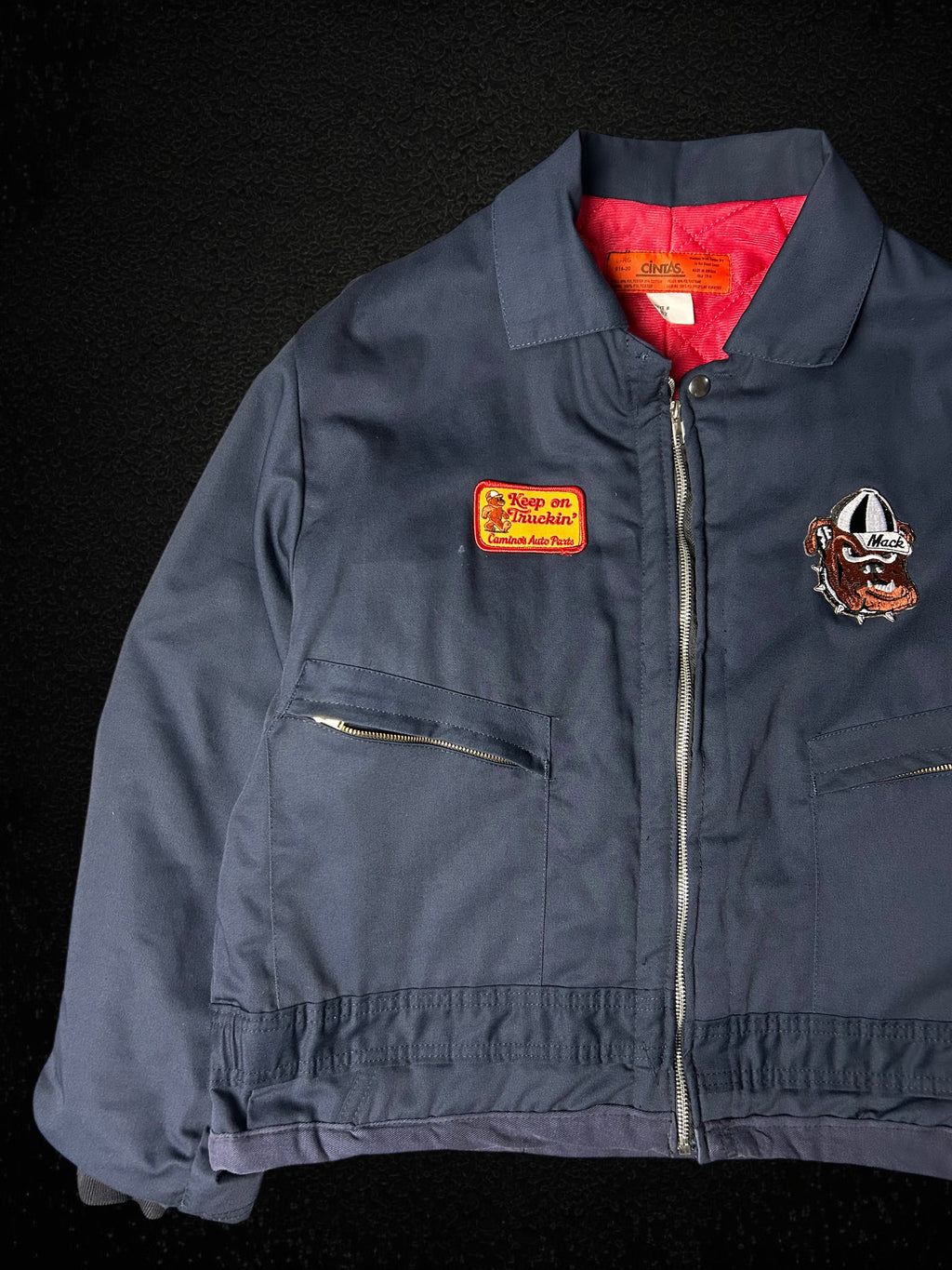Camino’s Auto Parts upcycled navy blue insulated trucker jacket with Mack Trucks bulldog and custom patches.
