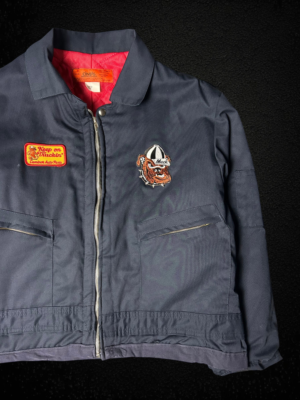Camino’s Auto Parts upcycled navy trucker jacket with Mack Trucks bulldog and Keep on Truckin patches, red lining.