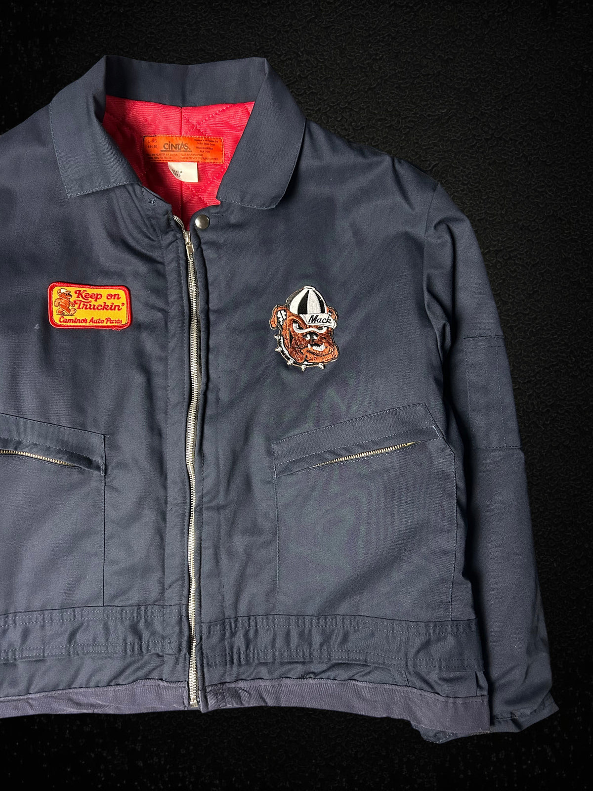 Camino’s Auto Parts upcycled navy trucker jacket with Mack Trucks bulldog and Keep on Truckin patches, red lining.