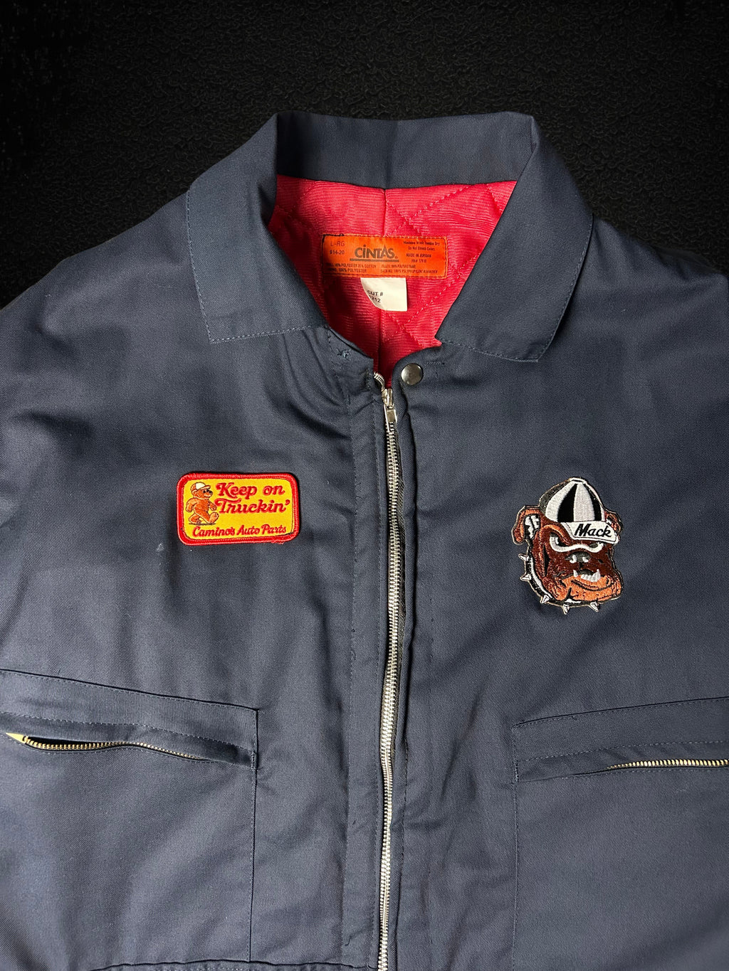 Camino’s Auto Parts upcycled navy trucker jacket with red quilted lining, Mack Bulldog and custom patches.