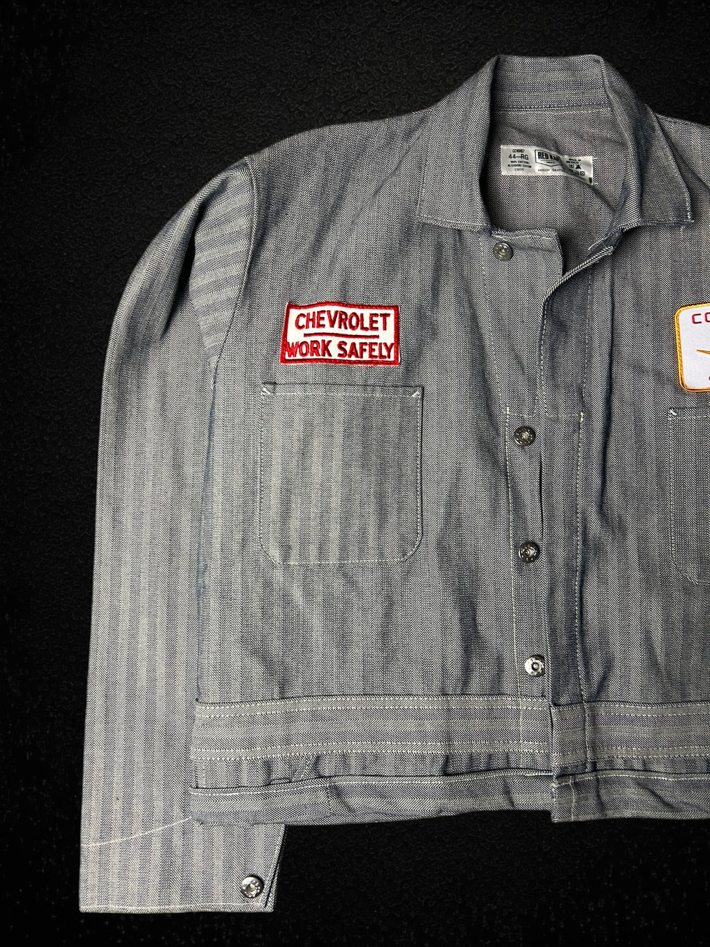 Camino’s Auto Parts reworked grey herringbone twill trucker jacket with Chevrolet Work Safely patch, size Large.