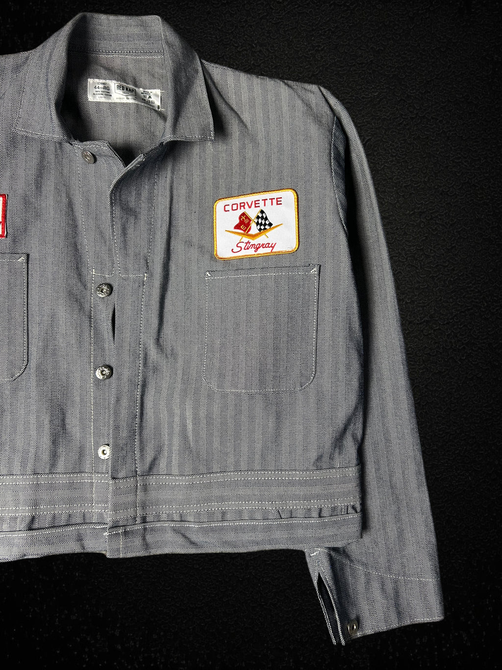 Camino’s Auto Parts reworked grey twill trucker jacket featuring a vintage Corvette Stingray patch on the chest.
