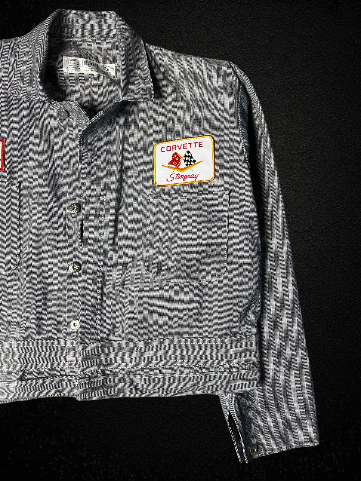 Camino’s Auto Parts reworked grey twill trucker jacket featuring a vintage Corvette Stingray patch on the chest.