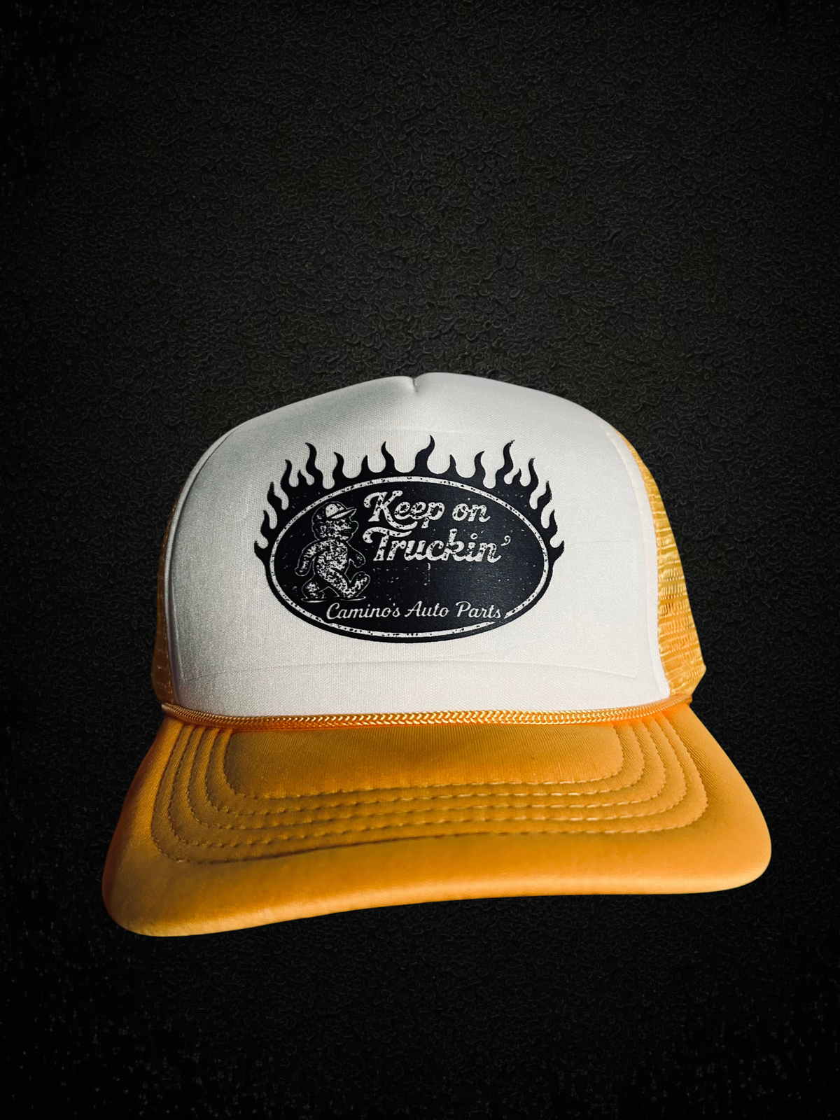 Camino’s Auto Parts vintage style trucker hat with white foam front, yellow mesh back, and Keep On Truckin graphic.